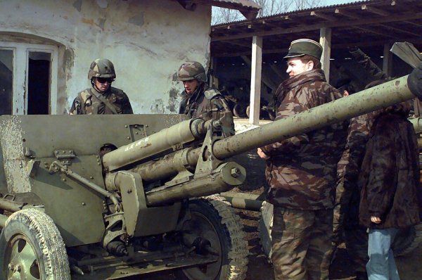 Serbian officer shows U. S. soldiers a towed ZiS-3 anti-tank